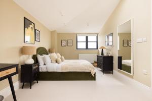 ein Schlafzimmer mit einem Bett und einem großen Spiegel in der Unterkunft The Tooting Hideout - Dazzling 3BDR Flat with Balcony in London