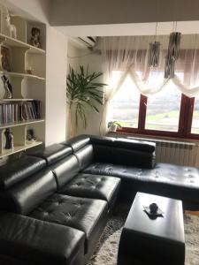 a black leather couch in a living room with a window at Sunny Luxury Apartment 2BDR in Bitola +16 photos