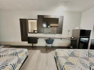 Habitación con 2 camas, escritorio y espejo. en Motel 6-Simpsonville, SC - Greenville, en Simpsonville