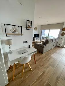 a living room with a desk and a couch at SeaHomes Vacations, LA CASA BLUE Mediterranean Lifestyle in Blanes