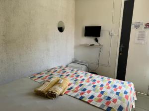 a bed with a quilt on it in a room at Casa da Esquina Pousada in Recife