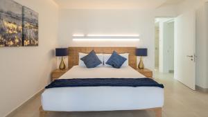 a bedroom with a large white bed with blue pillows at Costa Divina LV 12 Brand New by Kivoya in Puerto Peñasco