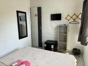 a small room with a bed and a television at Casa da Esquina Pousada in Recife