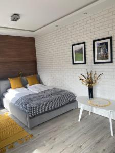 a bedroom with a bed and a white brick wall at Apartament CARPANO, Ogrodnicza 7 / KARPACZ in Karpacz