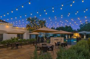 Villas at La Cantera Resort & Spa في سان انطونيو: فناء به طاولات ومظلات في الليل