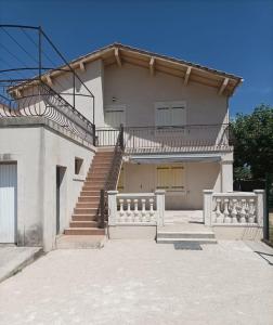 ein großes weißes Haus mit einer Treppe und einer Veranda in der Unterkunft Les garrigues in Pernes-les-Fontaines