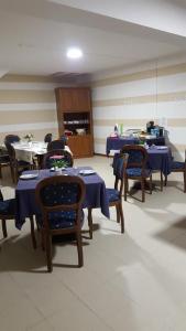 a dining room with tables and chairs with blue tablecloths at B&B White House in Melfi +15 photos