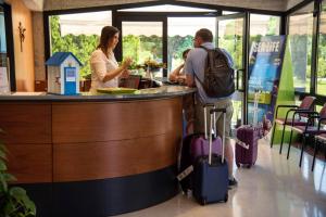 un homme et une femme debout dans un bar avec bagages dans l'établissement Centro Vacanze Opera Nascimbeni, à Cavallino-Treporti