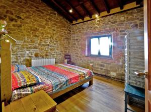 a bedroom with a bed and a brick wall at Precioso apartamento en plena naturaleza in La Cavada
