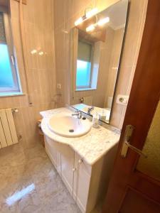 a bathroom with a sink and a mirror at A casa da Sia in Ribadeo +3 photos
