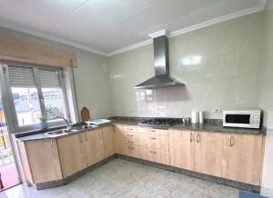 a kitchen with a sink and a microwave at A casa da Sia in Ribadeo