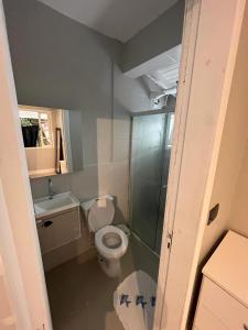a small bathroom with a toilet and a shower at Vale Beach Pousada in Itajaí