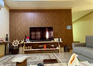 a living room with a flat screen tv on a wall at Endhaa, Divers Home in Fuvahmulah