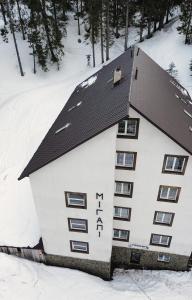 un bâtiment avec de la neige sur son côté dans l'établissement Мігалі, à Dragobrat