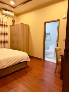 sypialnia z łóżkiem oraz łazienka z toaletą w obiekcie Endhaa, Divers Home w mieście Fuvahmulah