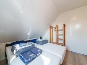 een slaapkamer met een wit bed met twee zakken erop bij Nice holiday home with sauna near a lake in Simonshaven