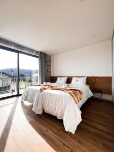 a bedroom with two beds and a large window at Paços do Douro, Chambre privée avec piscine in Romariz