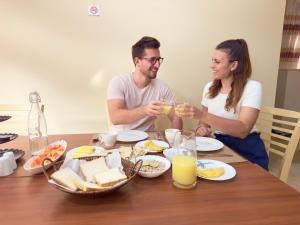 un hombre y una mujer sentados en una mesa bebiendo zumo de naranja en Endhaa, Divers Home en Fuvahmulah