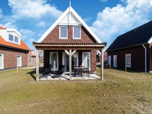 a house with a porch with a table in a yard at Nice holiday home with sauna near a lake in Simonshaven