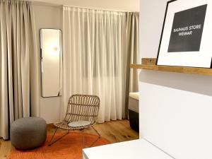 Hotel Wilma في فريكينهاوزين: غرفة معيشة مع كرسي ومرآة