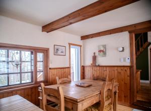 a dining room with a wooden table and chairs at Chalet “Lendemain de ville” avec accès au lac in Saint Adolphe D'Howard