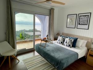 a bedroom with a bed and a large window at SeaHomes Vacations, LA CASA BLUE Mediterranean Lifestyle in Blanes