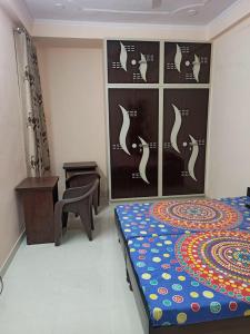 a bedroom with a bed and a table and a chair at Adinath Residency in Jaipur