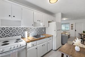 a kitchen with white cabinets and a white refrigerator at Charming cozy studio @ Lake Ridge in Fort Lauderdale