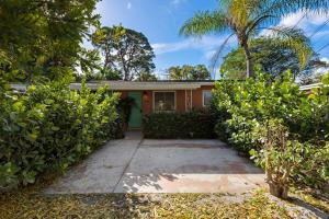 a house with a palm tree and a driveway at Charming cozy studio @ Lake Ridge in Fort Lauderdale