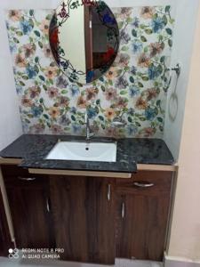 a bathroom with a sink and a mirror on the wall at Adinath Residency in Jaipur