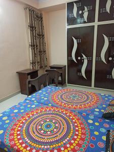 a room with a large bed with a colorful rug on it at Adinath Residency in Jaipur