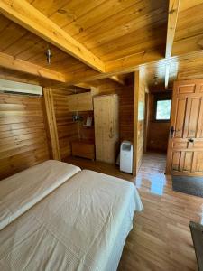 una camera con un letto in una cabina di legno di Hostal de Montaña Pous de la neu ad Alfara de Carles