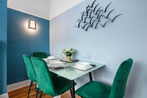 comedor con mesa y sillas verdes en New - Stylish 4 bedroom House, Business & Leisure. Discount on long stays. By Jesswood Properties., en Southend-on-Sea