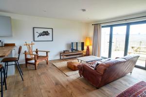 a living room with a couch and a table at Host & Stay - PigLets in Castle Acre