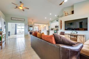 a living room with a leather couch and a kitchen at Pet-Friendly Fort Pierce Home with Deck and Pool! in Fort Pierce