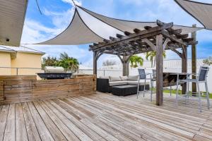 a patio with a grill and a wooden deck at Pet-Friendly Fort Pierce Home with Deck and Pool! in Fort Pierce