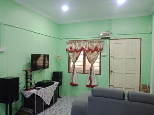 a living room with a couch and a window at Kuntum Cottage Bed & Breakfast in Kampong Tanjong Ipoh