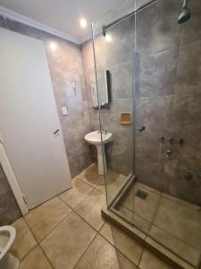 uma casa de banho com um chuveiro, um WC e um lavatório. em Hotel Firenze em Necochea