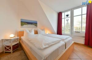 ein Schlafzimmer mit einem großen Bett und einem Fenster in der Unterkunft Villa Vogelsang Ferienwohnung 12 in Binz