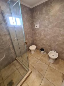 een badkamer met een douche, een toilet en een wastafel bij Hotel Firenze in Necochea