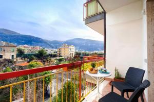 balcón con mesa, sillas y vistas en Maison Alessia - Around Sorrento, en Sorrento