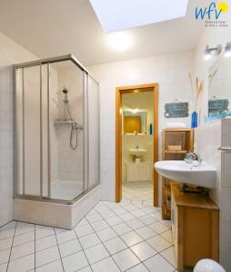 ein Bad mit einer Dusche und einem Waschbecken in der Unterkunft Villa Vogelsang Ferienwohnung 12 in Binz