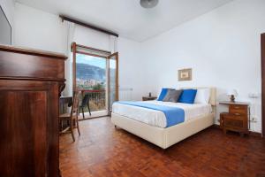 a bedroom with a bed and a large window at Maison Alessia - Around Sorrento in Sorrento