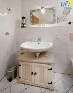 ein Bad mit einem Waschbecken und einem Spiegel in der Unterkunft Villa Vogelsang Ferienwohnung 11 in Binz