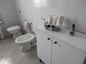 Un baño blanco con inodoro y lavabo. en Casa Vacanze Farinella, en Putignano