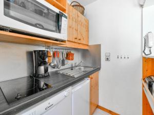 a kitchen with a sink and a microwave at Appartement rénové près des pistes avec terrasse, ski, parking et cuisine équipée - FR-1-514-48 in Courchevel