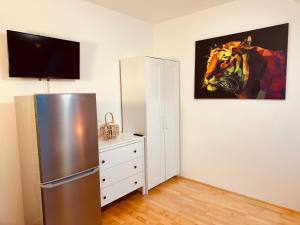 een keuken met een koelkast en een schilderij van een paard bij Enns Sleep in Enns