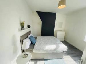 a white bedroom with a bed and a lamp at Suite 2 - Cosy Private Room in Old Swan in Liverpool