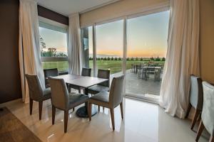 a dining room with a table and chairs and a large window at Hotel Bel Posto by Tandem in Realicó