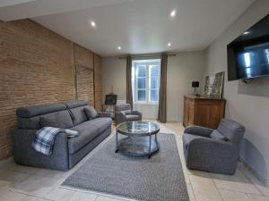 a living room with two couches and a tv at Gîte familial rénové avec piscine, jardin de 1 hectare et vélos à disposition, situé en pleine campagne - FR-1-591-579 in Tilly